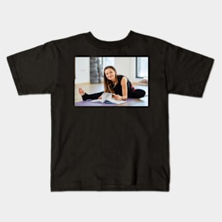 Young woman reading a yoga book Kids T-Shirt